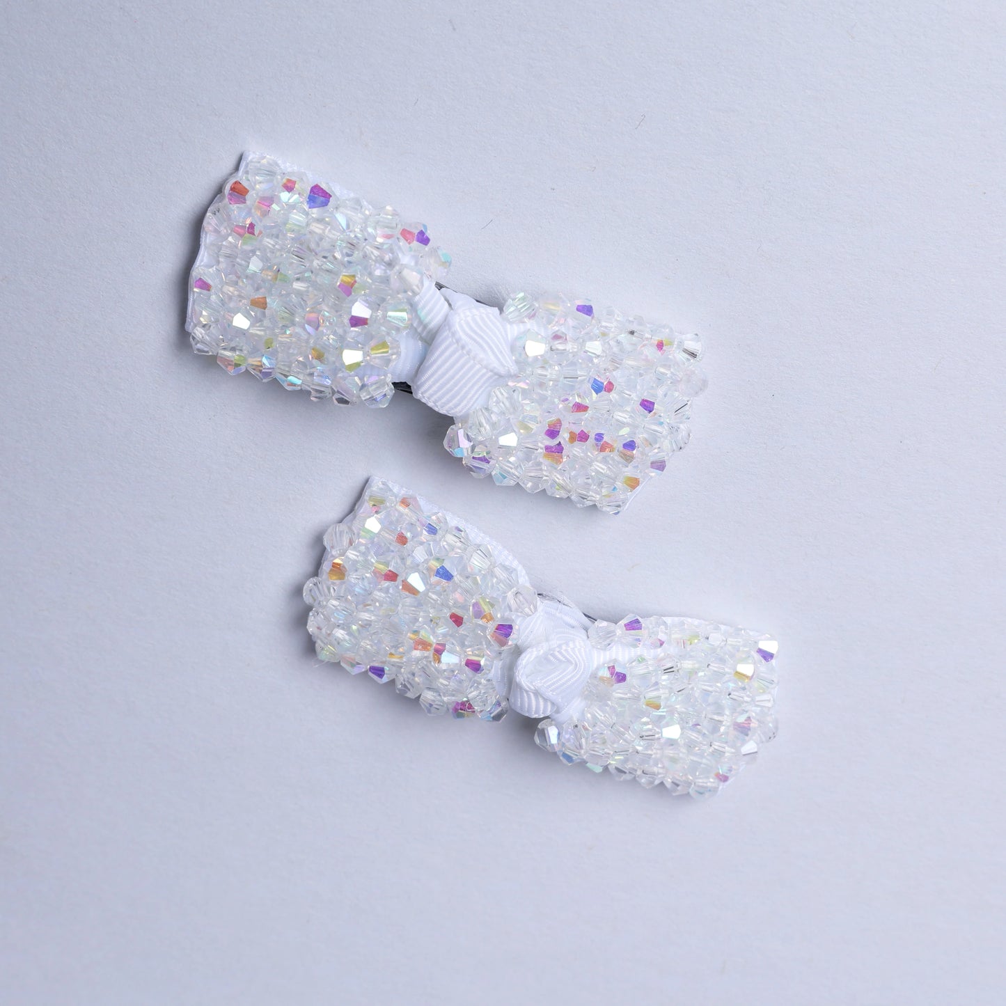 Pair of crystal bow hair pins with white ribbon and sparkling multicolor crystals