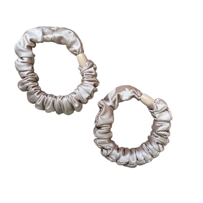 Two onion pink scrunchies on a light gray background