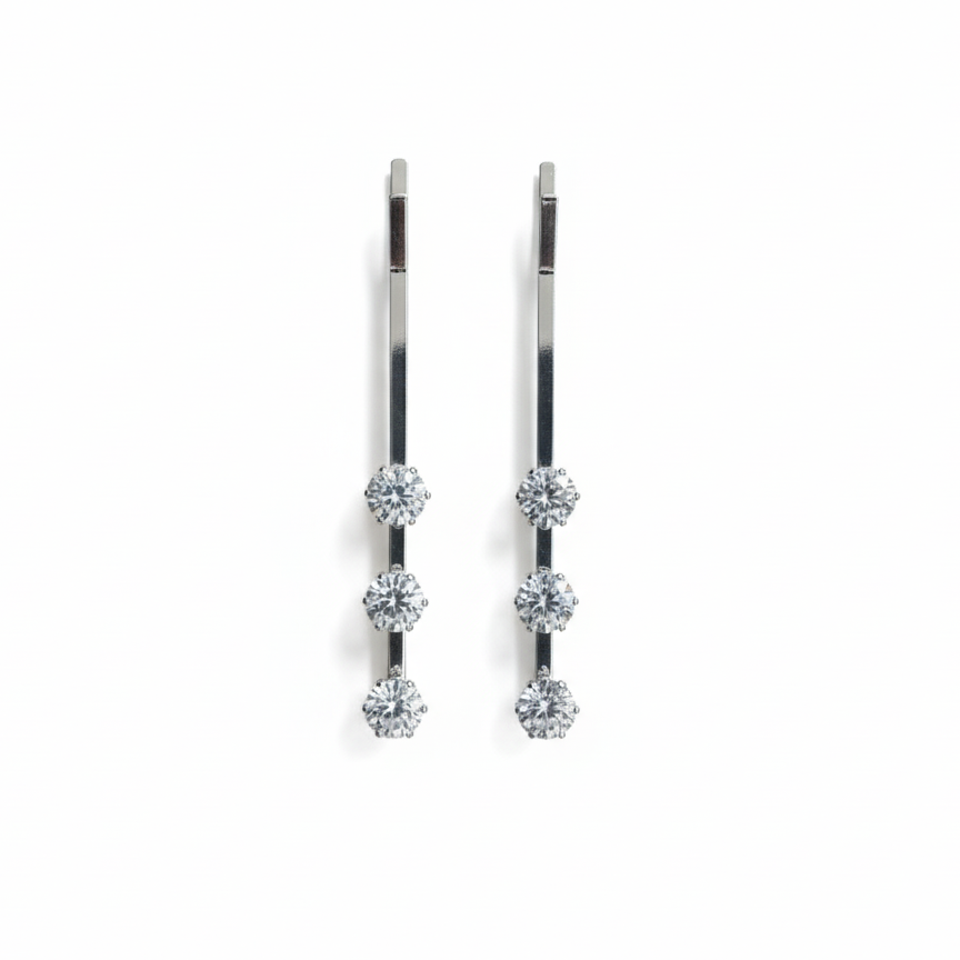 Pair of silver pins with multiple gemstones on a white background