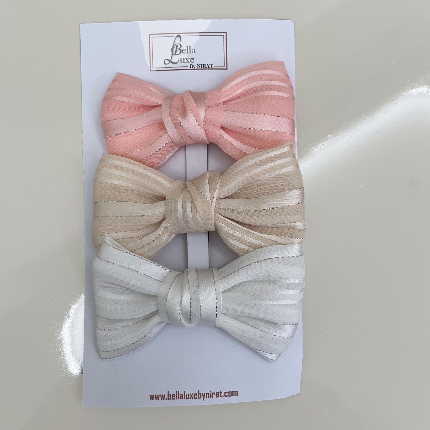 Bella Luxe soft georgette bow clips in pink beige and white colors on branded card