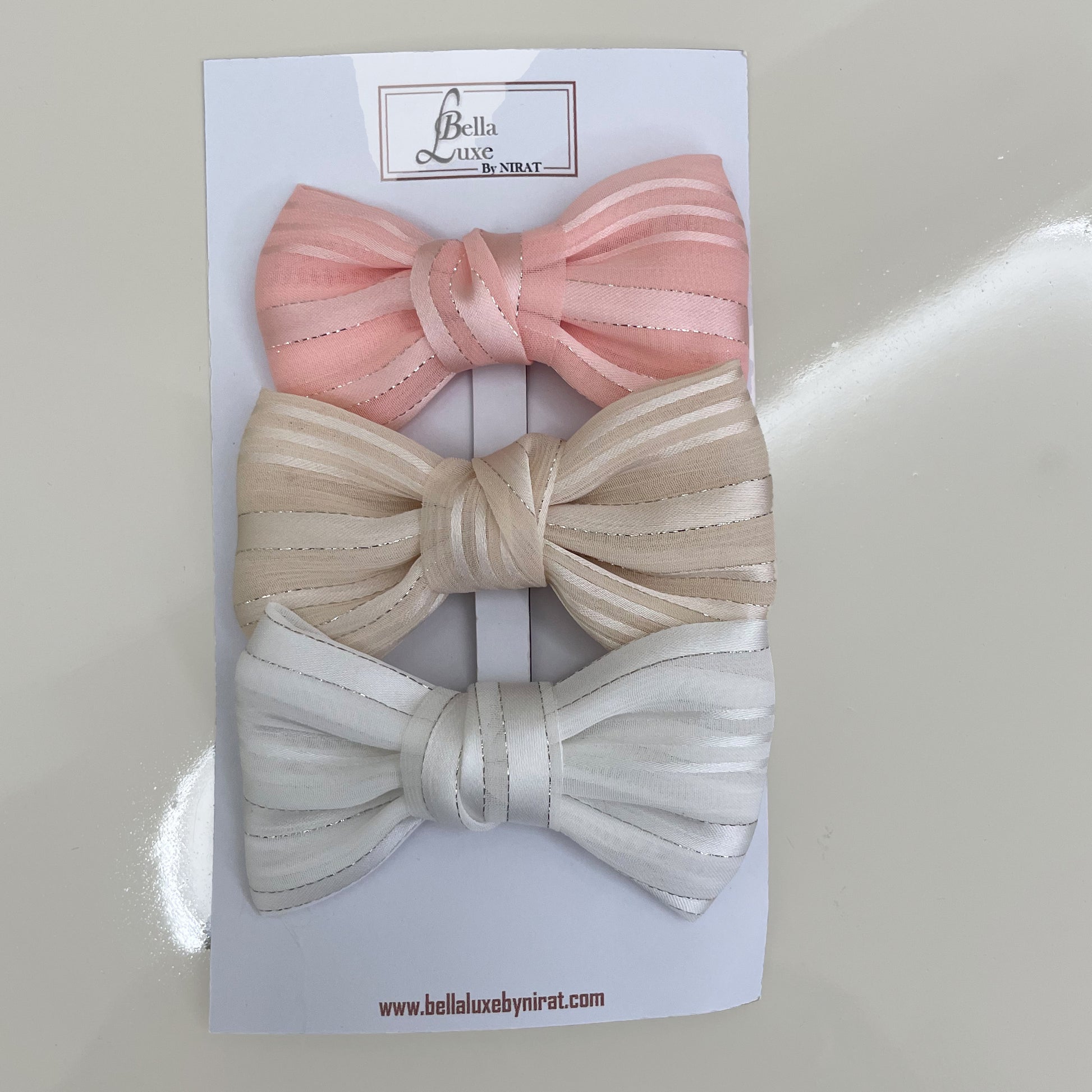 Bella Luxe soft georgette bow clips in pink beige and white colors on branded card