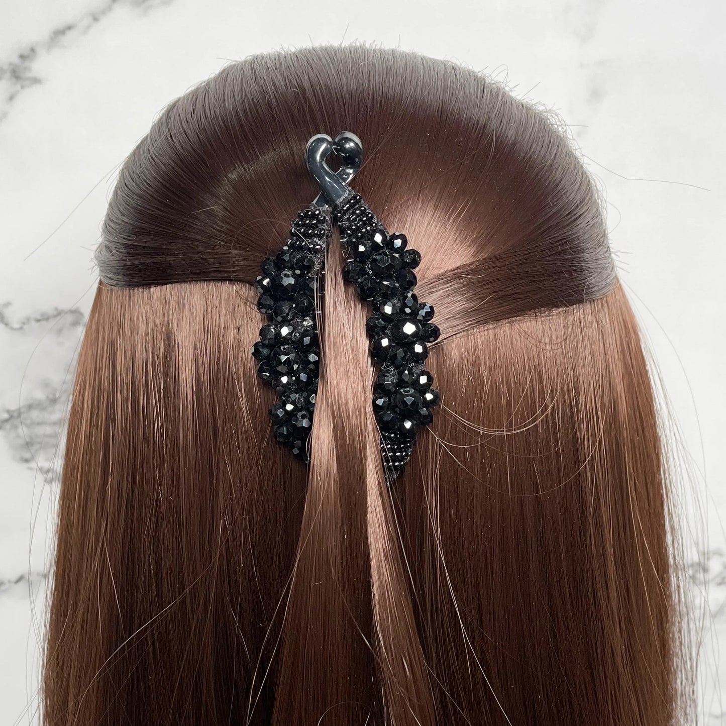 Bella Luxe black crystal studded banana clip securing brown hair in a half-up hairstyle