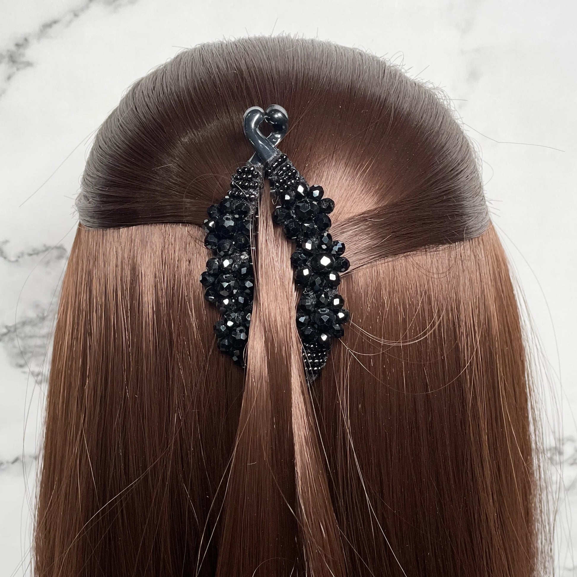 Bella Luxe black crystal studded banana clip securing brown hair in a half-up hairstyle