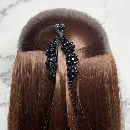 Bella Luxe black crystal studded banana clip securing brown hair in a half-up hairstyle