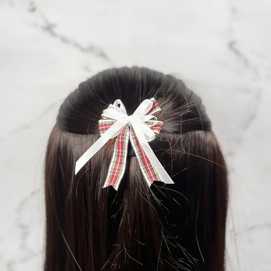 Striped and white ribbon stylish bow clips for kids attached to brown hair