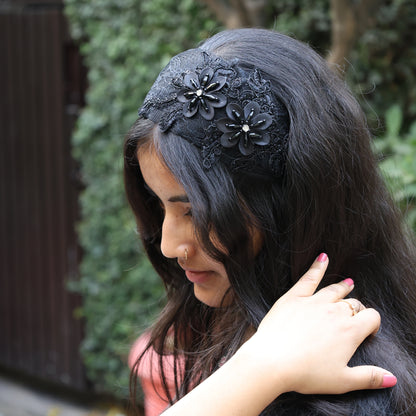 Black broad flower hairbands with lace and floral embellishments worn by woman with long dark hair