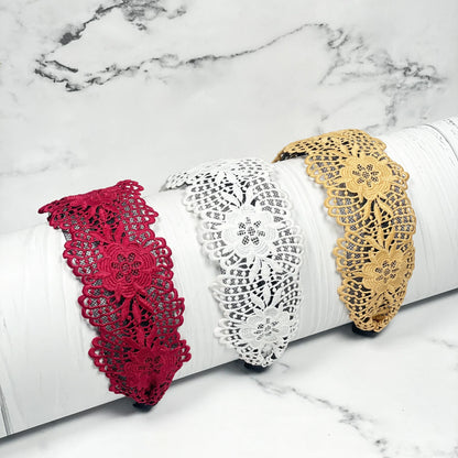 Broad lace hairbands in red white and beige floral design displayed on white surface