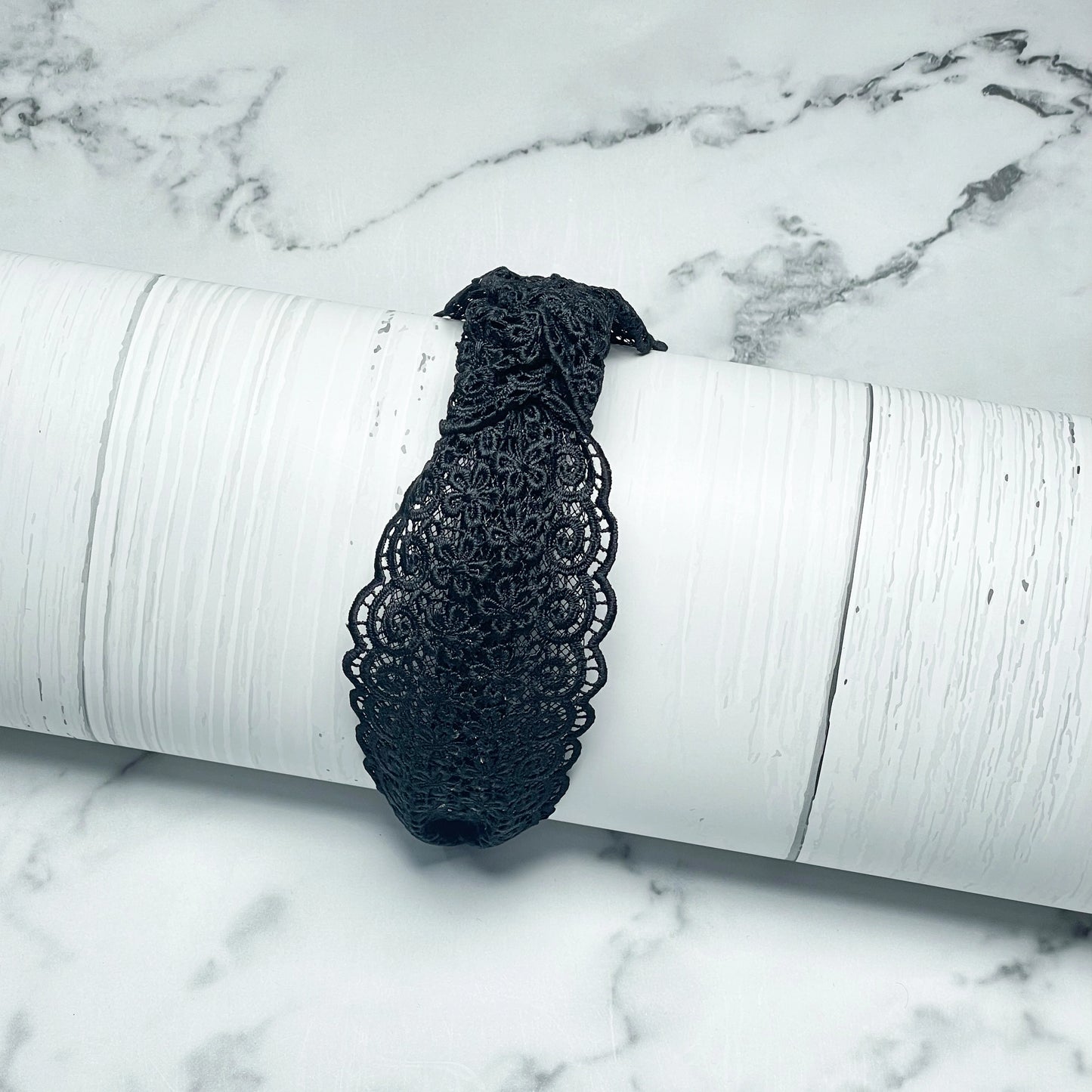 Black Broad Lacy Knotted Hairbands with intricate floral lace design displayed on white textured background