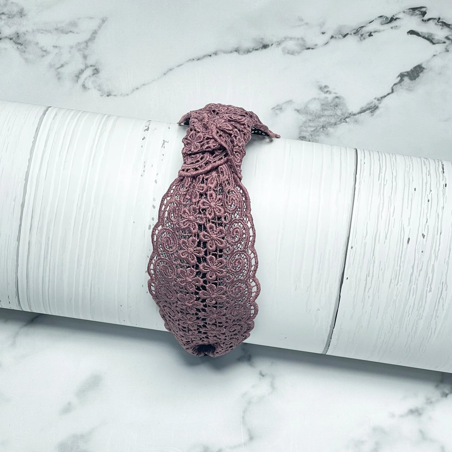 Broad Lacy Knotted Hairbands in dusty pink with floral lace design displayed on white textured surface