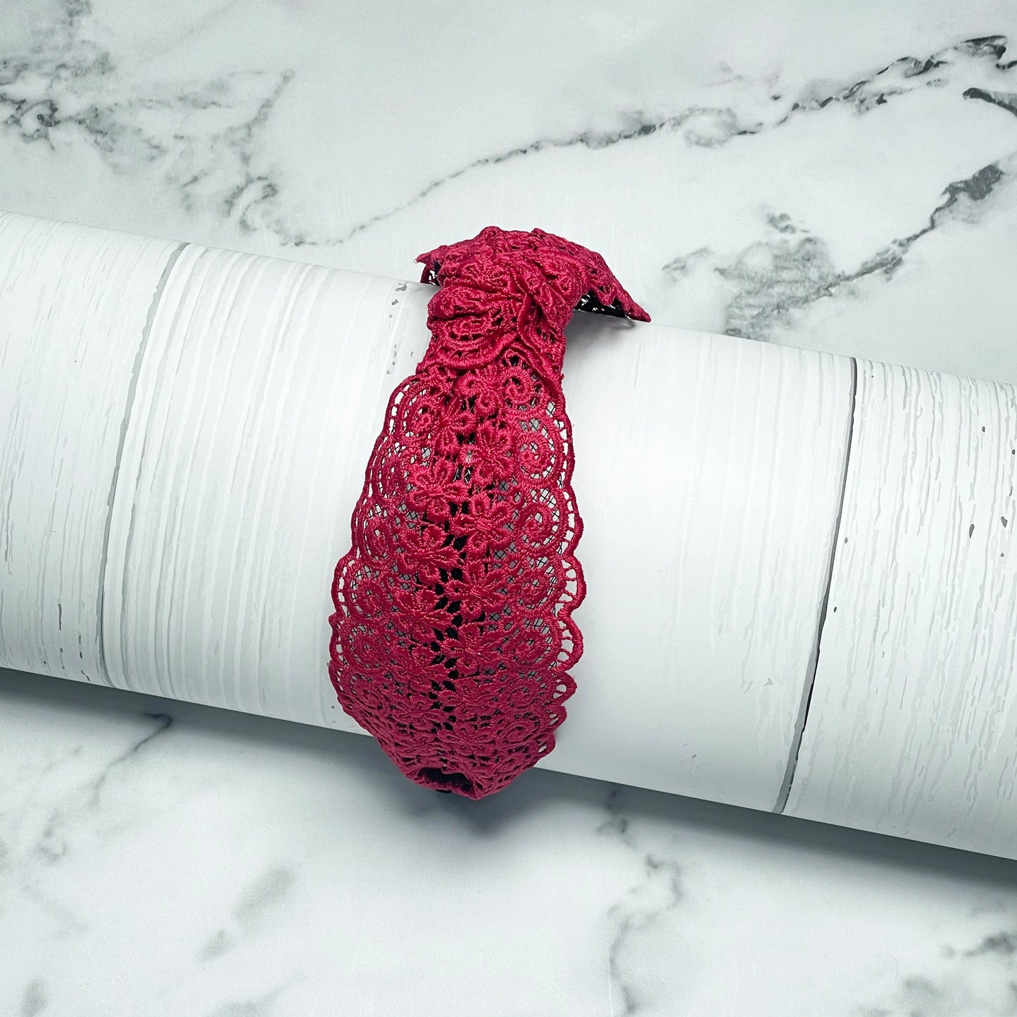 Red Broad Lacy Knotted Hairbands with intricate floral lace design displayed on white textured surface