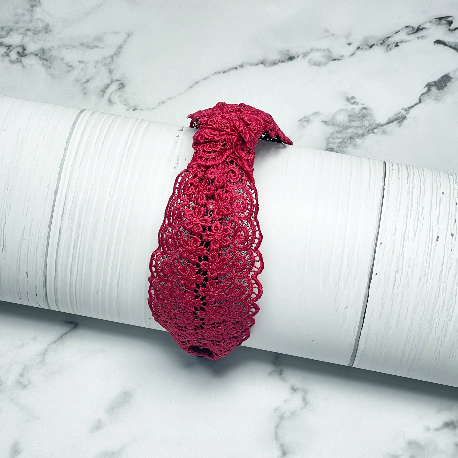 Red Broad Lacy Knotted Hairbands with intricate floral lace design displayed on white textured surface