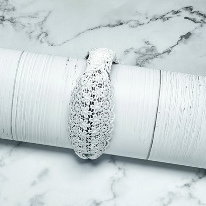 White Broad Lacy Knotted Hairbands displayed on textured white cylindrical prop