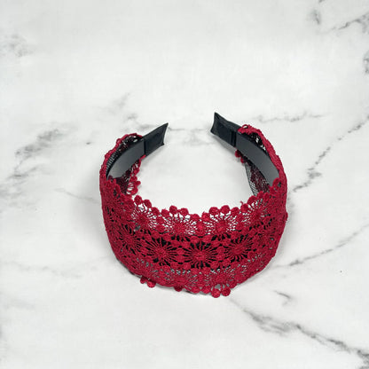 Broad red lacy hairband with intricate floral design and black inner band