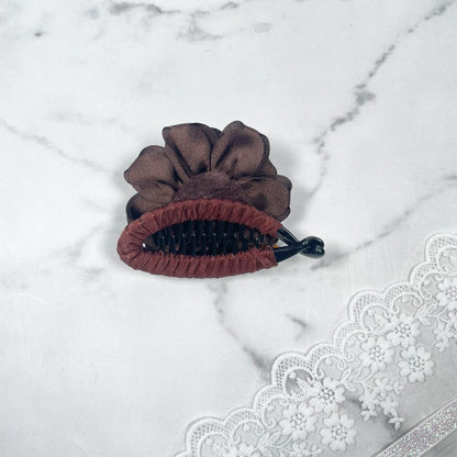 Bella Luxe brown flower crystal banana clip with fabric flower detail on marble surface