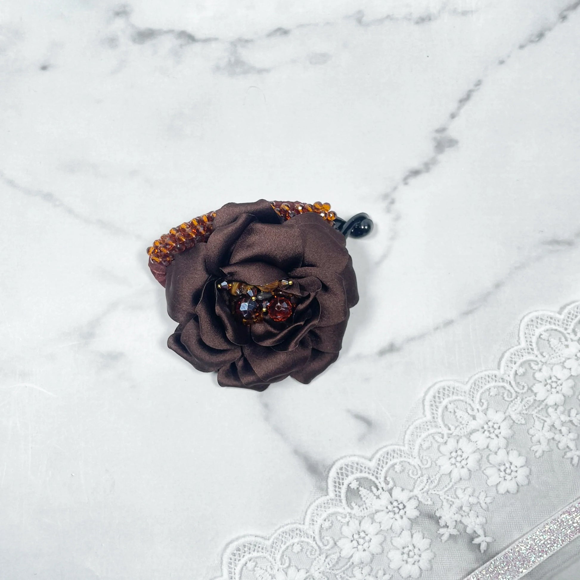 Brown flower crystal banana clip by Bella Luxe featuring a fabric flower with crystal embellishments