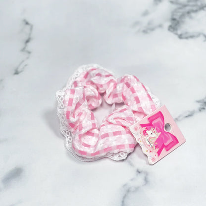 Pink and white check scrunchies with lace trim laid on marble surface from mydevelopmentstor