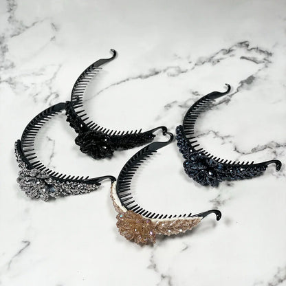 Set of four crystal studded hair bun clips in black, silver, and gold colors on marble background