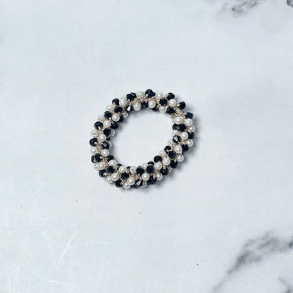 Black and white crystal studded hair ties featuring pearl and bead embellishments on white marble background