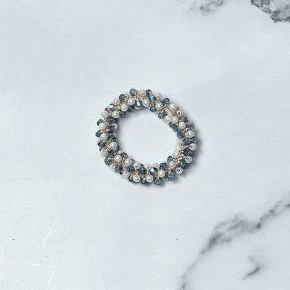 Crystal studded hair ties with pearl and bead embellishments on marble surface