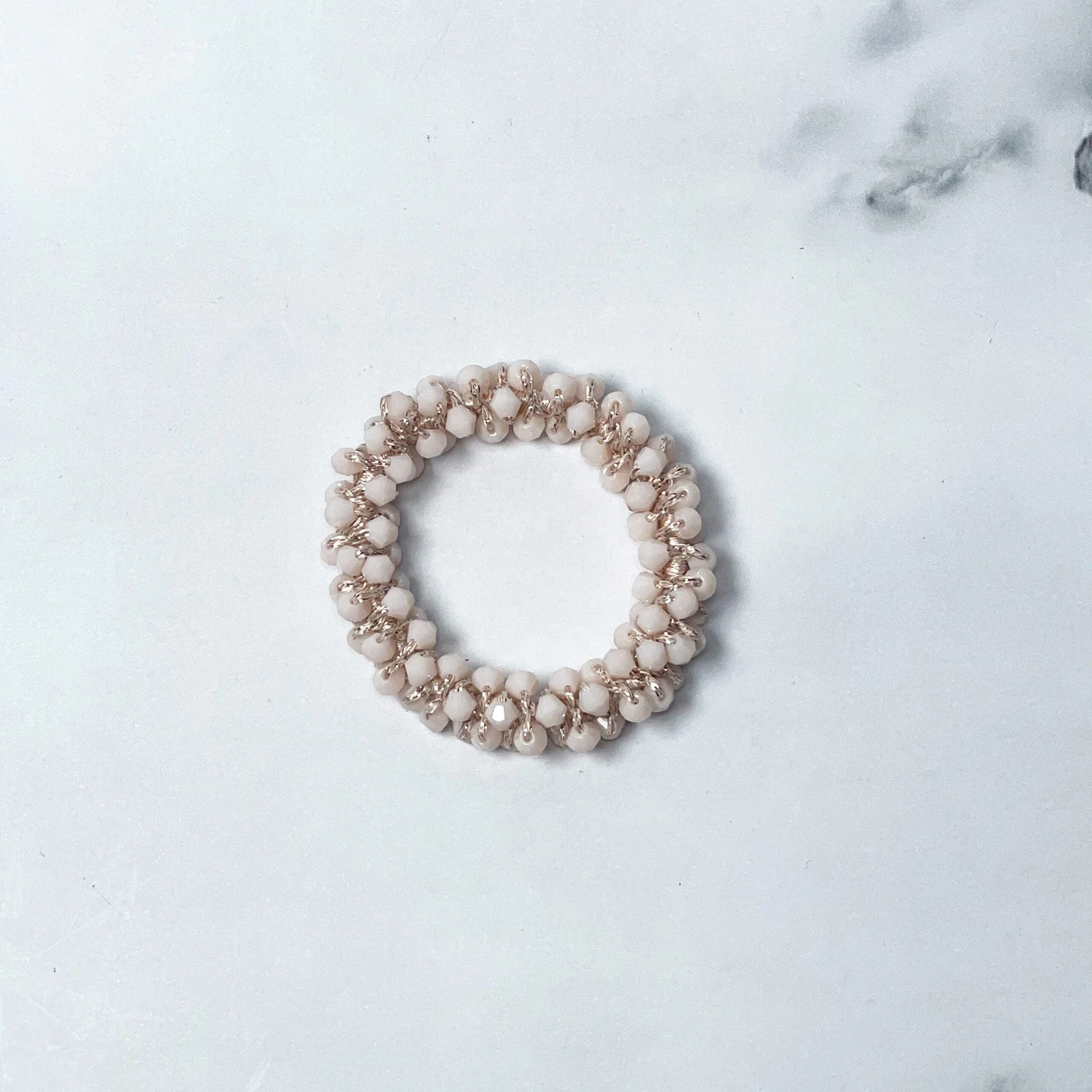Beige crystal studded hair ties with small round beads arranged in a circular design