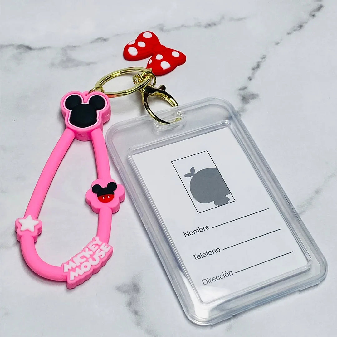 Pink Mickey Mouse disney tag key chains with clear ID holder and red polka dot bow charm on marble surface