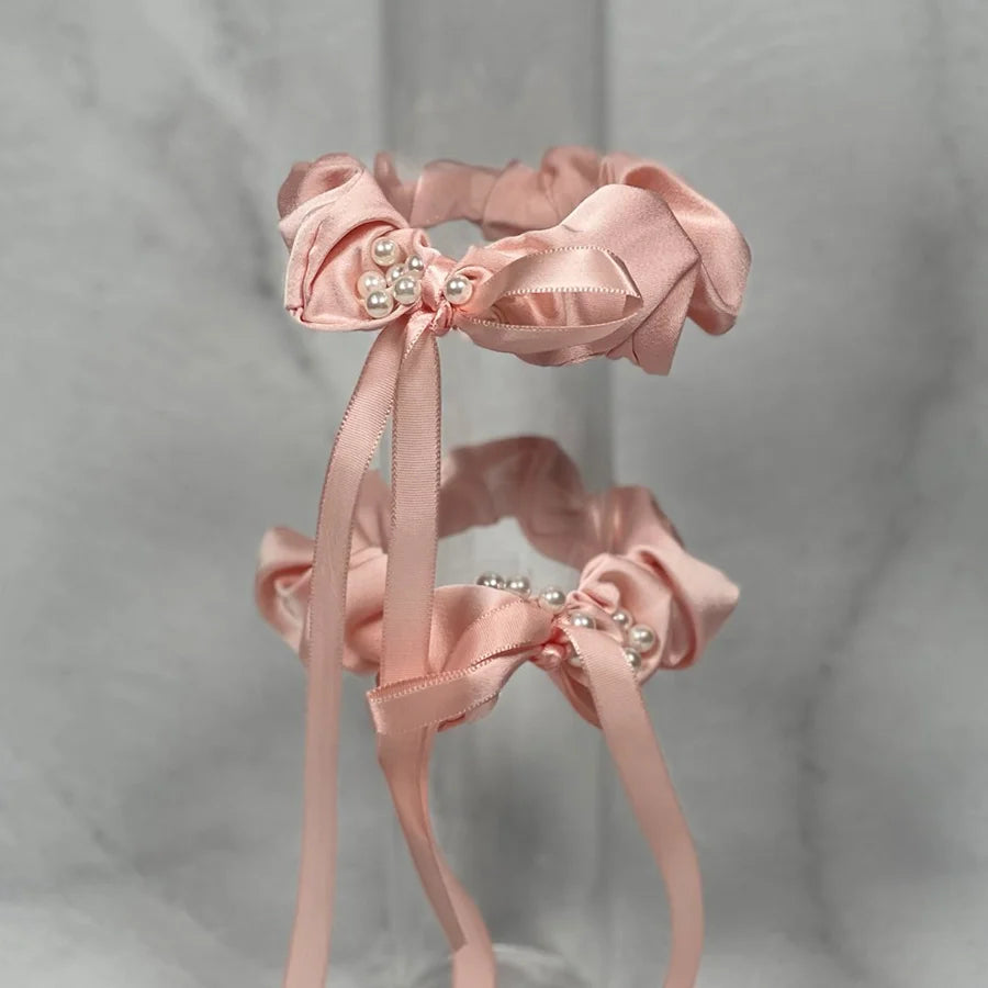 Elegant beaded ribbon hair tie in soft pink with pearl details and flowing satin ribbons