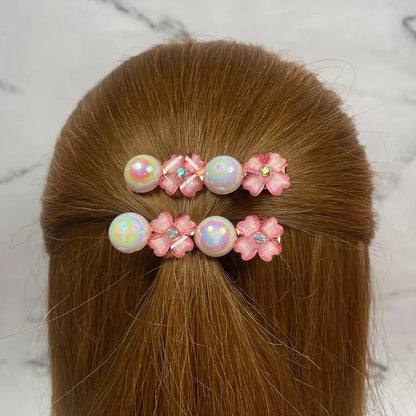 Fancy pearl flower hair pins with pink flowers and iridescent pearls styled in brown hair