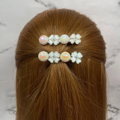 Fancy pearl flower hair pins adorned on light brown hair, featuring iridescent pearls and delicate white flowers