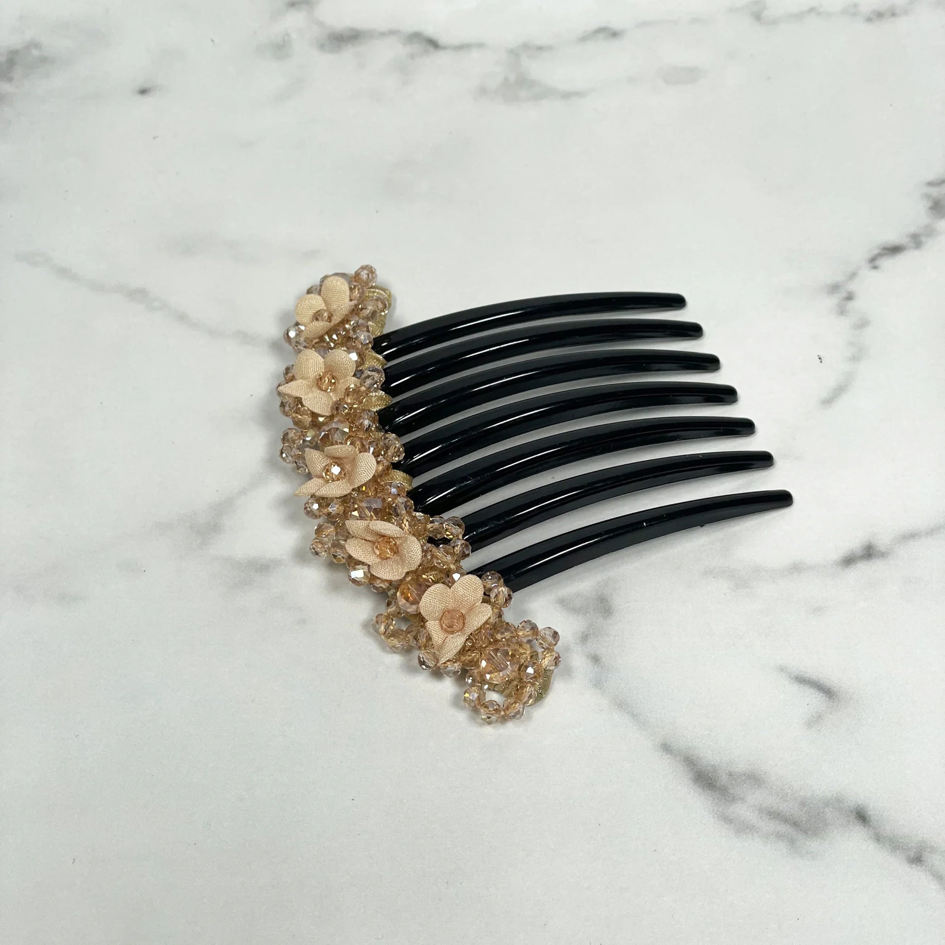 Black hair comb with beige floral beaded hair comb clips detailed decoration on marble background