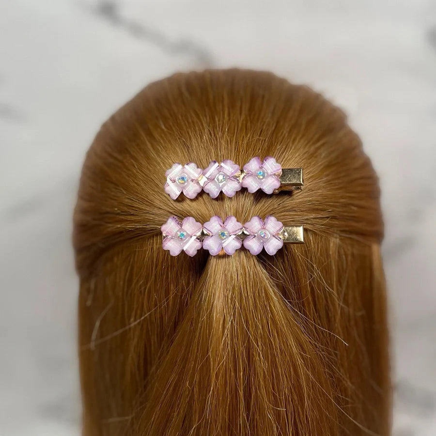 Pink floral hair pins for women with rhinestone accents clipped in light brown hair