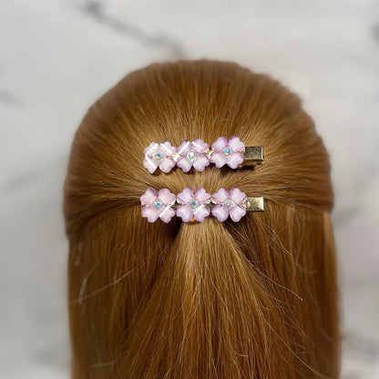 Pink floral hair pins for women with rhinestone accents clipped in light brown hair