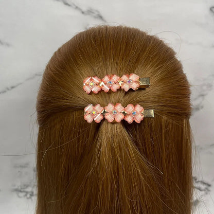 Pink floral hair pins for women with small gemstones worn on light brown hair