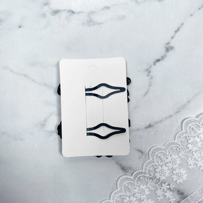 Black flower crystal hair pins displayed on white card with lace fabric background