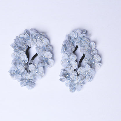 Pair of delicate flower crystal hair pins with light blue floral design and shimmering crystals