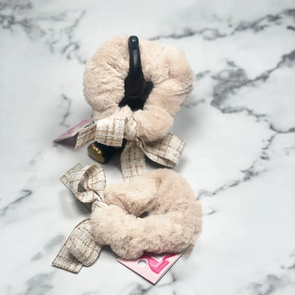 Beige fur scrunchie with check ribbon tied in bow, displayed on marble surface