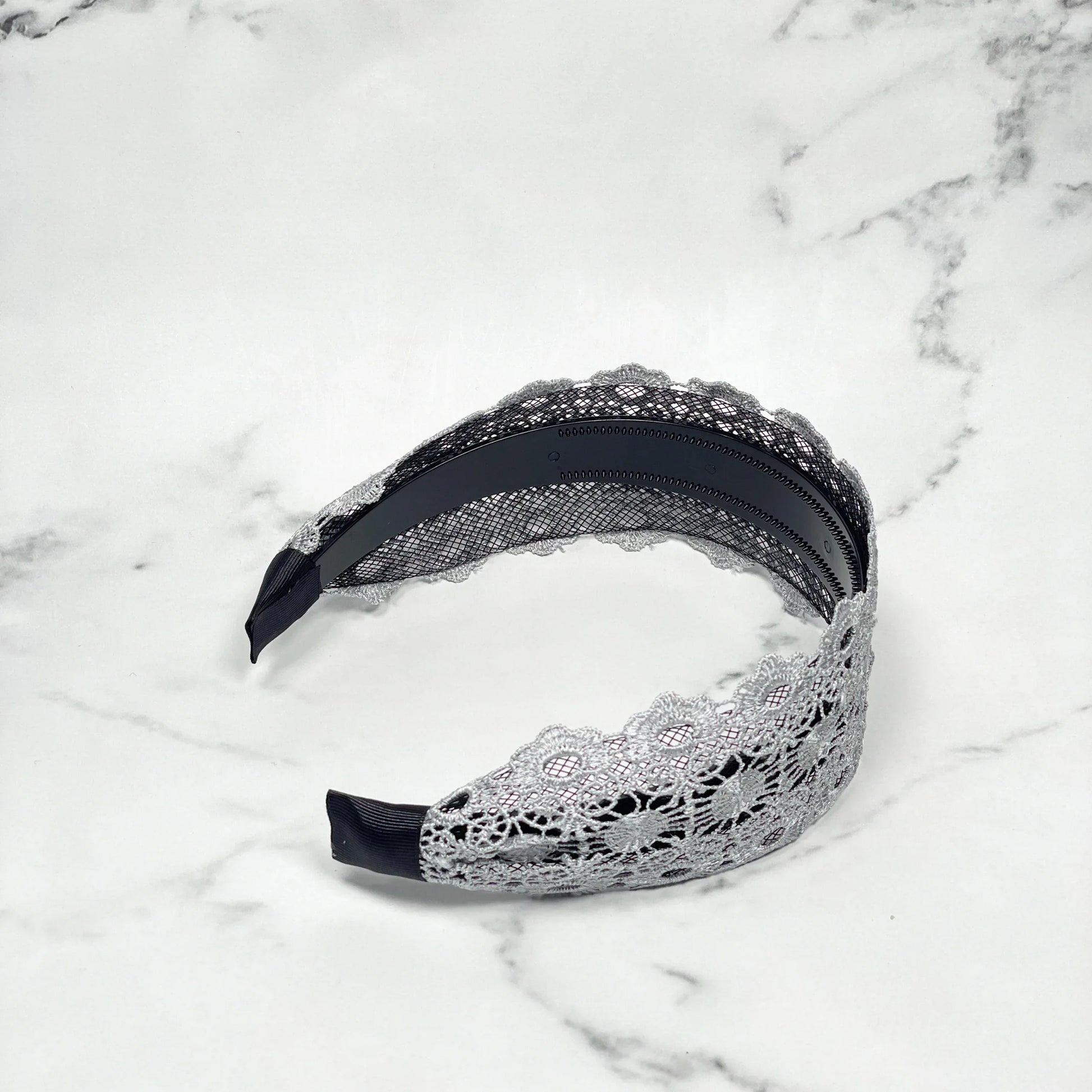 Grey lacy hairband with intricate floral lace design and black inner band for comfortable wear