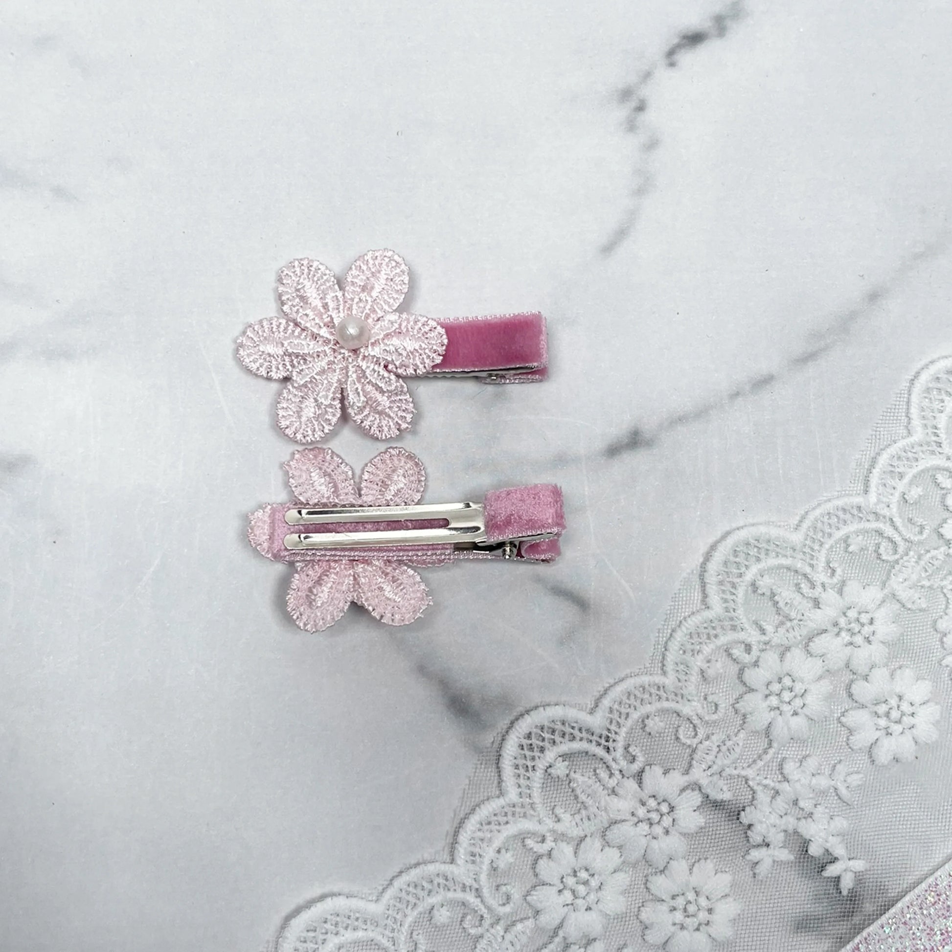 Lacy Flower Alligator Hair Pins with Beads in pink lace design on a marble surface with lace fabric