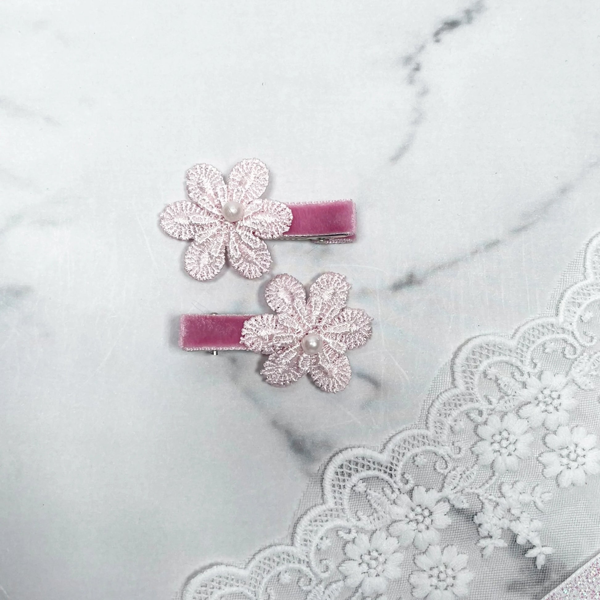 Lacy Flower Alligator Hair Pins with Beads in soft pink on velvet clips displayed on lace fabric
