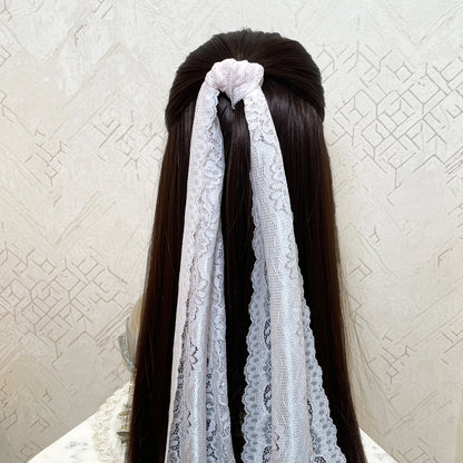 Light pink lacy hair scarf tied on long dark brown hair with decorative lace patterns