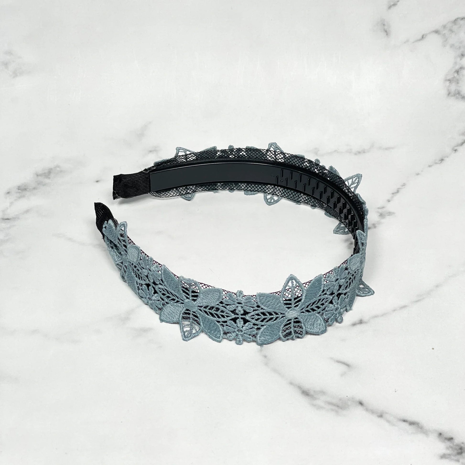 Medium broad colored hair bands with blue lace floral design on a white marble background