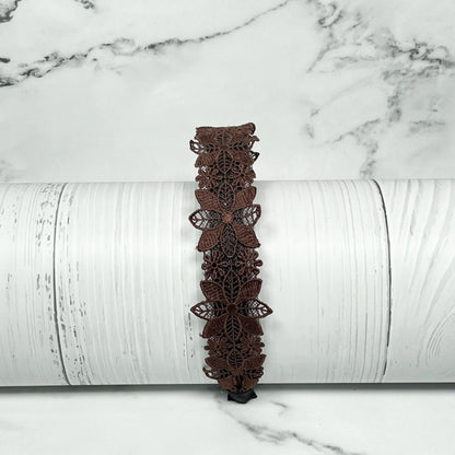 Brown medium broad colored hair bands with butterfly lace design displayed on white wooden background