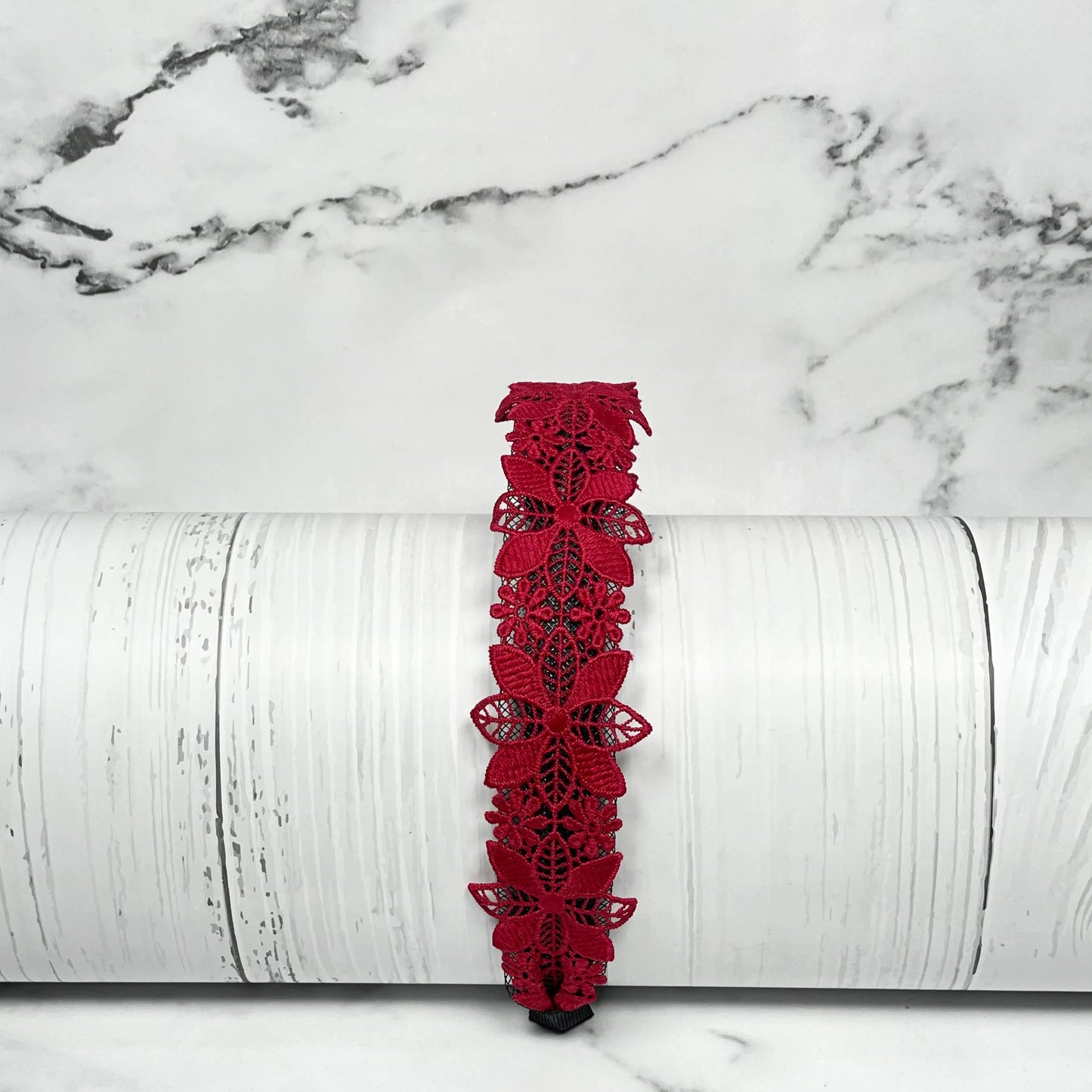 Red medium broad colored hair bands with floral lace design displayed on a white textured background