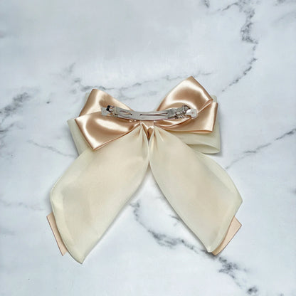 Organza and Satin Bow Clips in soft beige and cream colors with metal clip on marble background