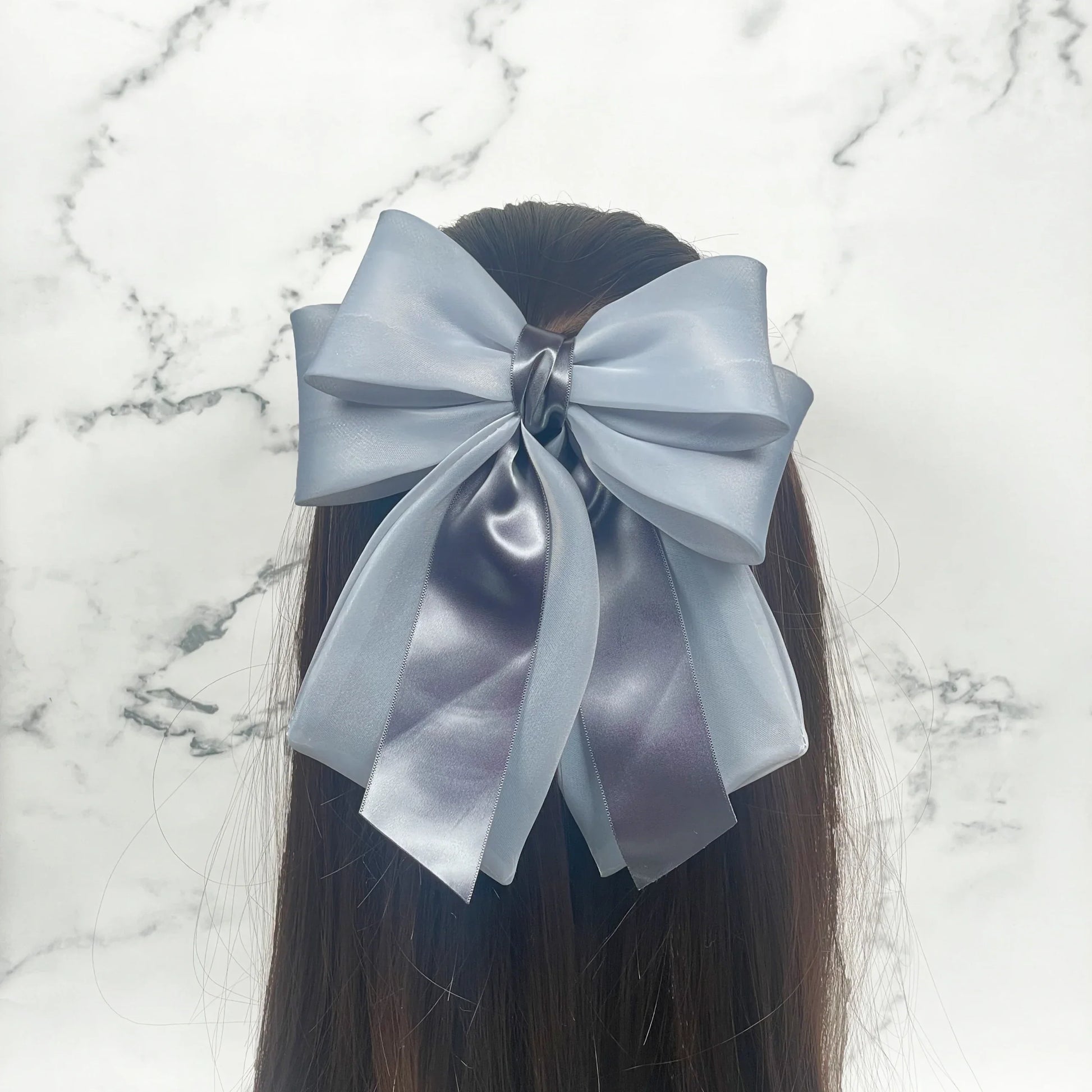 Large gray Organza and Satin Bow Clips worn on long dark hair with marble background