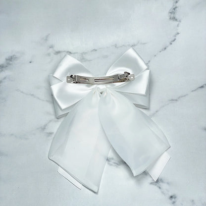 White Organza and Satin Bow Clips with silver metal clasp on marble background