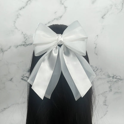 White Organza and Satin Bow Clips worn in long black hair with marble background