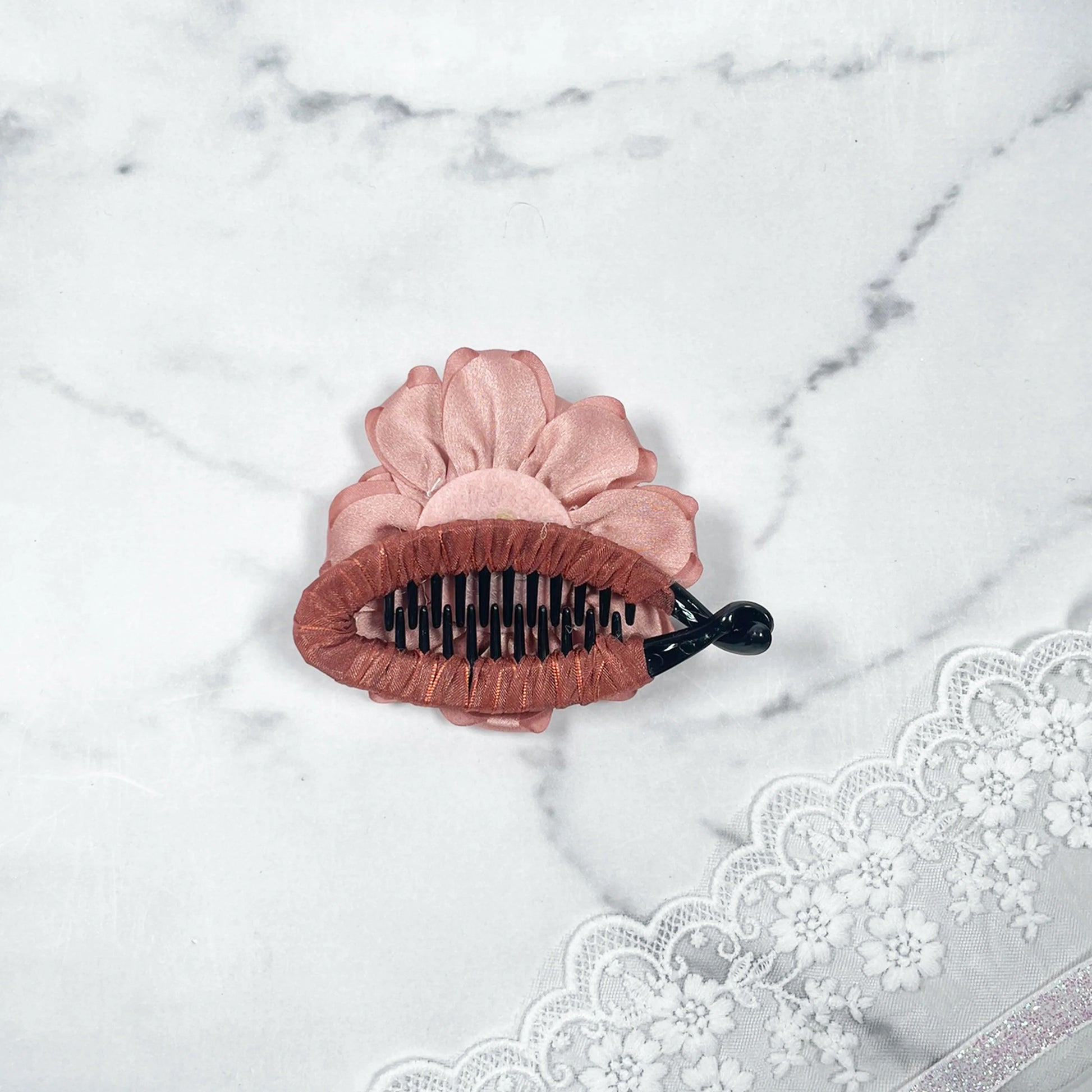 Bella Luxe peach crystal banana clips with flower design on marble background