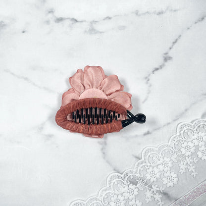 Bella Luxe peach crystal banana clips with flower design on marble background