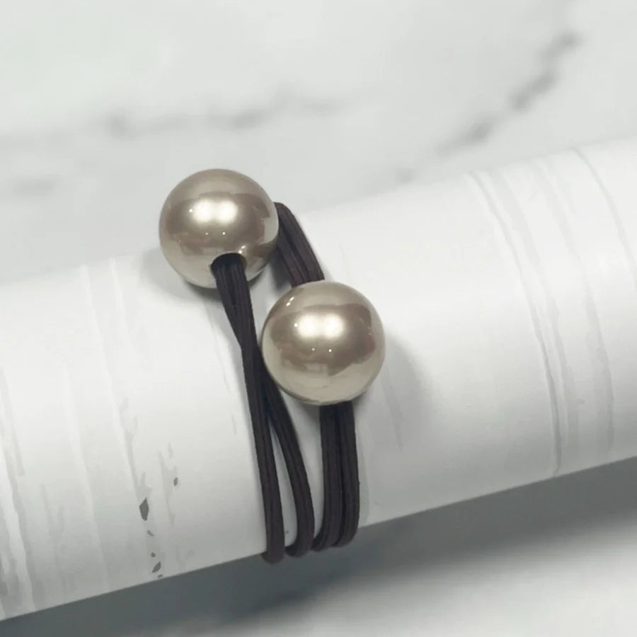 Black elastic pearl bead hair ties featuring large shiny pearls for stylish hair accessories