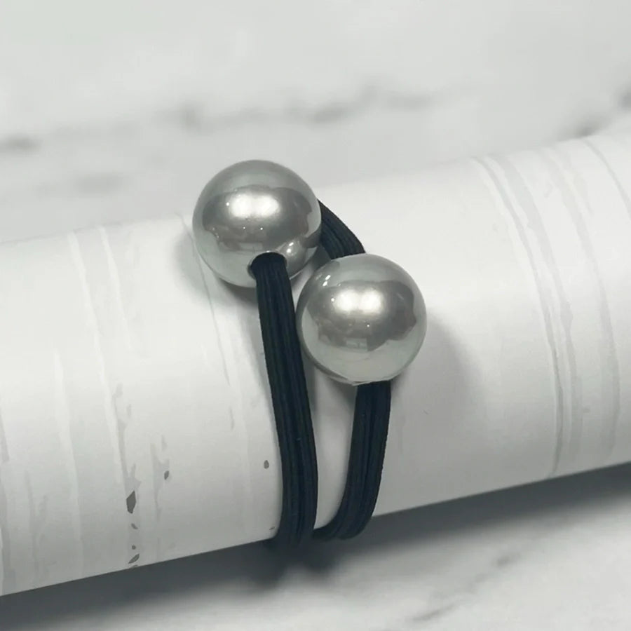 Black elastic pearl bead hair ties with two large shiny silver pearls on white background